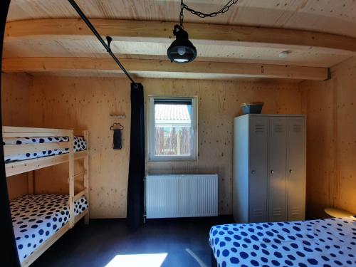 a room with two bunk beds and a window at ZTLND Familylodge in Zoutelande