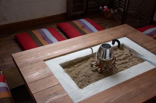 a table with a pot in the sand in a room at Guest Cafe Kuchikumano in Kamitondacho