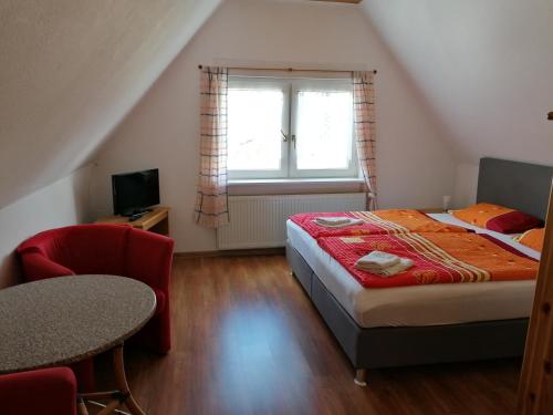 ein Schlafzimmer mit einem Bett, einem Stuhl und einem Fenster in der Unterkunft Pension und Bistro" Dat olle Fischerhus" in Ralswiek