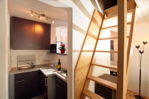 a small kitchen with a ladder leading into a tiny apartment at Ferienwohnung Ruberto in Hopfgarten im Brixental