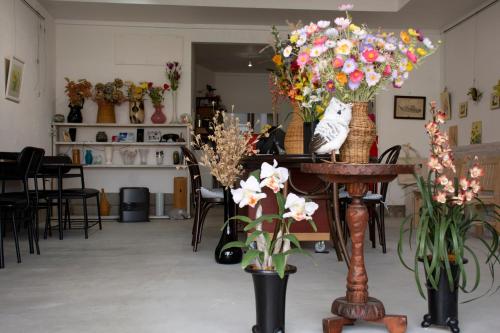 a room with flowers in vases on a table at Guest Cafe Kuchikumano in Kamitondacho