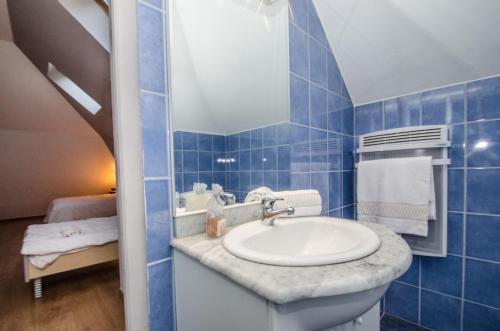 Baño de azulejos azules con lavabo y espejo en Résidence Androsace, en Chamonix-Mont-Blanc