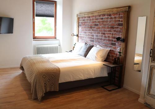 um quarto com uma parede de tijolos e uma cama em Pension Leano em Nötsch