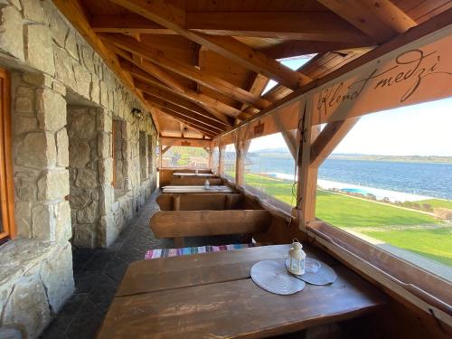 a row of benches in a restaurant with a view of the water at Slanický Dvor in Námestovo