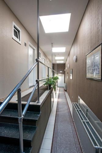 a hallway of a building with stairs and plants at Parkhotel Gent Centrum in Ghent