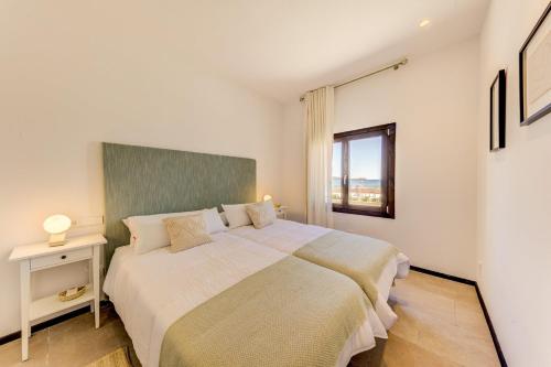 Un dormitorio con una cama grande y una ventana. en Beach Villa Silver by Sealand Villas, en Puerto Pollensa