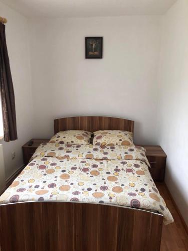 a bed with a wooden head board in a bedroom at Casa Dobra in Arieşeni
