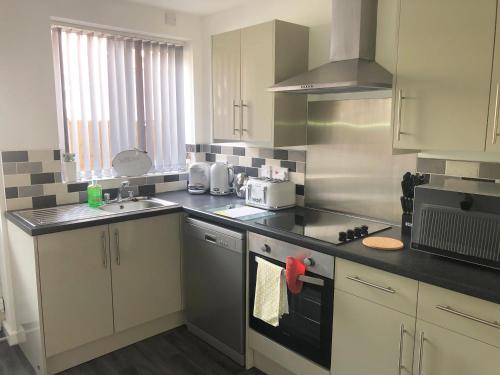 a kitchen with a sink and a stove top oven at Coastal Retreat - Skegness in Skegness