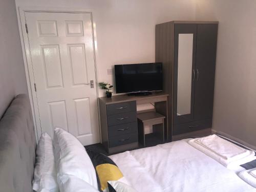 a bedroom with a bed and a dresser with a television at Coastal Retreat - Skegness in Skegness