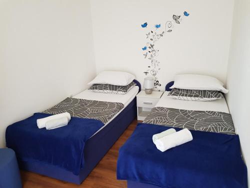 two beds in a room with blue and white at Apartment Anna 2021 in Poreč