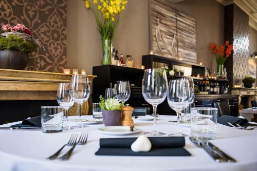a table with wine glasses and napkins in a restaurant at Parkhotel Gent Centrum in Ghent