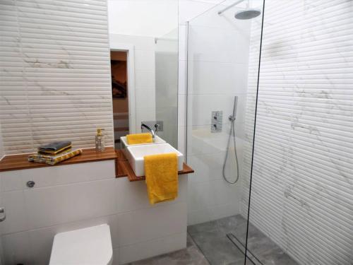 a white bathroom with a sink and a shower at Black Cart House in Johnstone