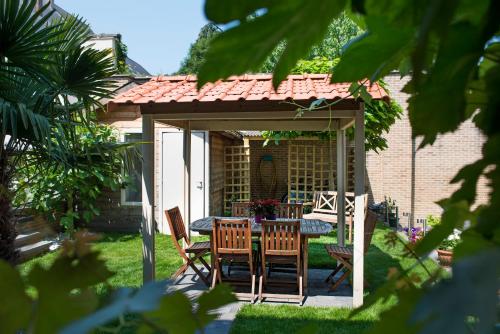 a gazebo with a table and chairs in a yard at Parkhotel Gent Centrum in Ghent