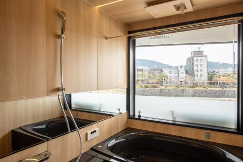 een keuken met een spoelbak en een raam bij TABITABI STAY KAWAMA in Kyoto