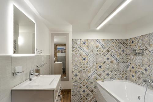biała łazienka z wanną i umywalką w obiekcie Filomena Suite Luxury Apartment w Katanii