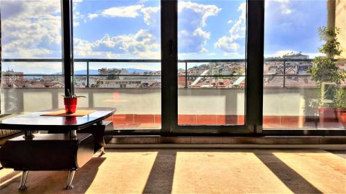 a room with a table in front of a large window at Sunny Days - Park Apartment in Sandanski