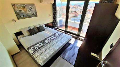a small bedroom with a bed and a window at Sunny Days - Park Apartment in Sandanski