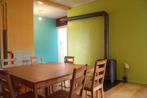 a dining room with a wooden table and chairs at La Colonie, ancienne usine horlogère in Les Pommerats