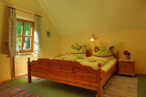a bedroom with a wooden bed with pillows on it at Gästehof Annerl in Rossleithen