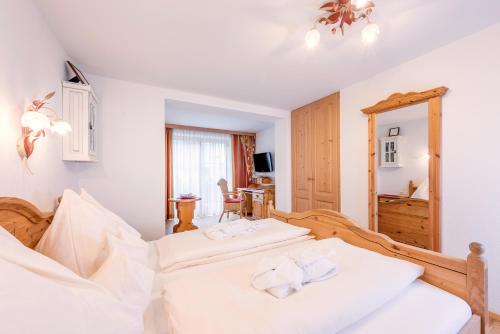 a bedroom with two white beds and a desk at Adults Only Boutique-Hotel Unterlechner in Sankt Jakob in Haus
