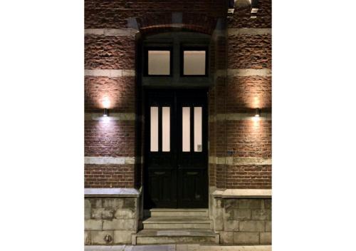 a black door on the side of a brick building at Boutique Hotel Huys van Steyns in Tongeren