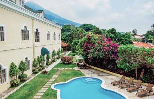 an exterior view of a building with a swimming pool in a yard at Hotel Mirador Plaza in San Salvador