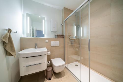 a bathroom with a toilet and a glass shower at Haus Heidelberg in Göhren