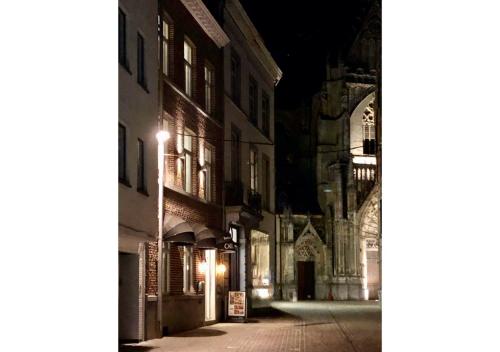 eine leere Stadtstraße in der Nacht mit einer Kathedrale in der Unterkunft Boutique Hotel Caelus VII in Tongeren