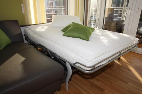 ein Krankenhausbett mit einem grünen Kissen darauf in der Unterkunft Wohnen am Yachthafen W45 in Cuxhaven
