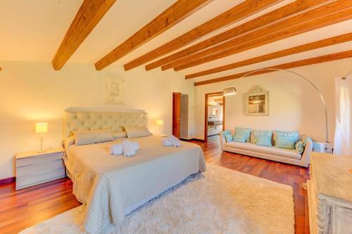 a large bedroom with a bed and a couch at Can Cladera in Pollença