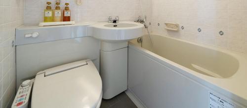 a bathroom with a toilet and a sink and a bath tub at Okazaki New Grand Hotel in Okazaki