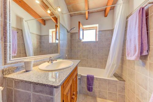 a bathroom with a sink and a tub and a mirror at Can Seguinot Mercer by Sealand Villas in El Port