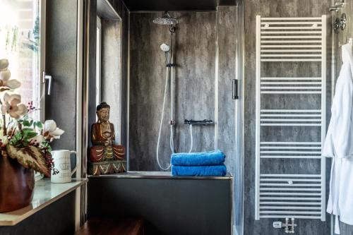 a bathroom with a shower with a blue towel at Landhaus Calluna in Undeloh