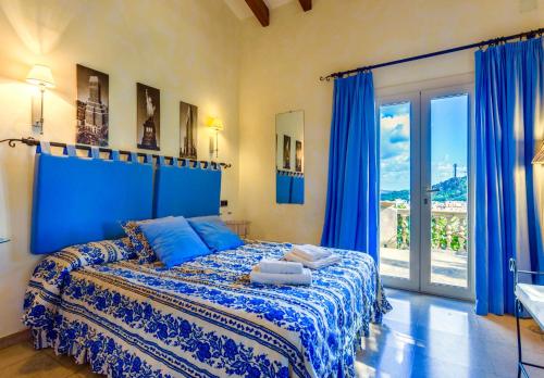 a blue bedroom with a large bed with blue curtains at Villa Calvario in Pollença