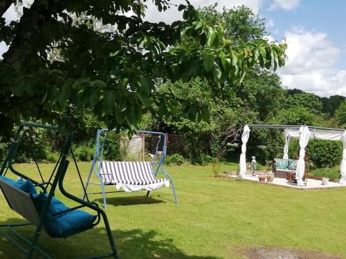 a swing in a garden with a gazebo at The apartment in Saint-Rabier