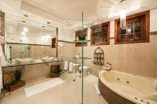 a bathroom with a tub and a toilet and a sink at Quinta da Paz Resort in Itaipava