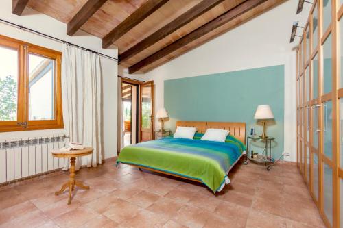 a bedroom with a green bed in a room at Villa Aumadrava Gran by Sealand Villas in El Port