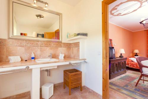 a bathroom with a sink and a mirror and a bed at Villa Aumadrava Gran by Sealand Villas in El Port