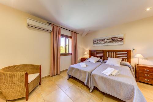 ポリェンサにあるVilla Pontarroのベッドルーム1室(ベッド2台、椅子、窓付)