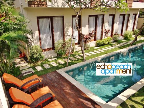 
a pool with a pool table and chairs at Echo Beach Villa and Apartment in Canggu

