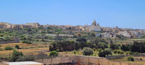 a view of a city with buildings on a hill at Il Bejta penthouse in Qala