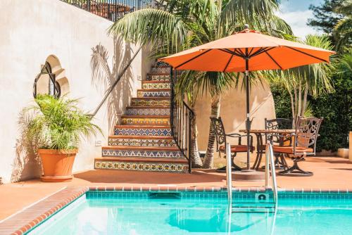 a pool with a table and an umbrella and stairs at Brisas Del Mar Inn at the Beach in Santa Barbara
