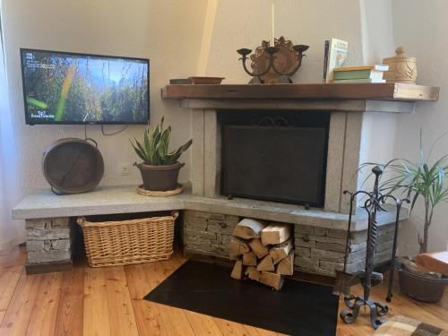 a living room with a stone fireplace with a flat screen tv at Casa Ornella in Courmayeur