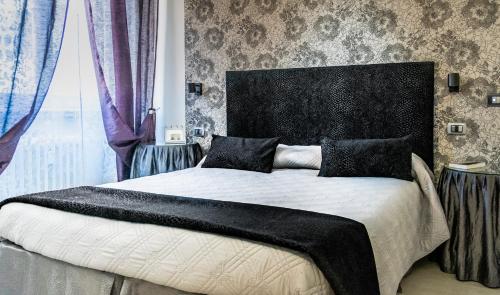 B&B Flo في فلورنسا: غرفة نوم مع سرير كبير مع اللوح الأمامي الأسود