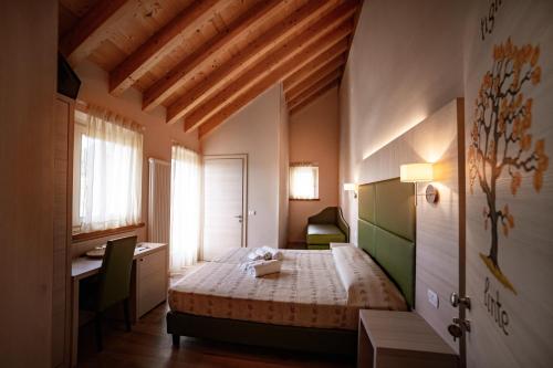 een slaapkamer met een bed en een bureau in een kamer bij Malga Zebari in Velo Veronese