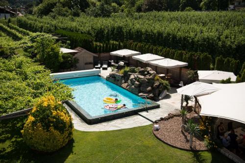 einen Blick über den Pool im Garten in der Unterkunft Hotel Frangart an der Weinstraße in Appiano sulla Strada del Vino