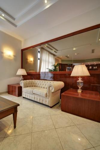 a living room with a couch and a large mirror at Astor Hotel in Turin