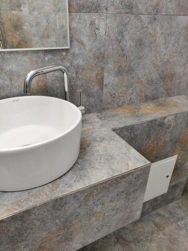 a bathroom with a white sink on a marble counter at Pensiunea Pictorilor in Baia Mare