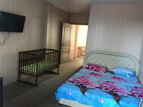 a bedroom with a bed with pink flowers on it at Villa Bossa in Zatoka