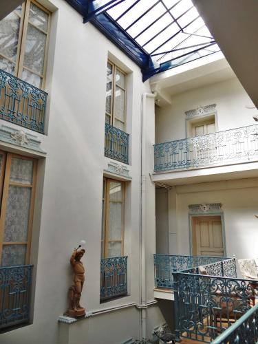 een gebouw met blauwe balkons en een dakraam bij HOTEL MARCEILLAC in Castelsarrasin